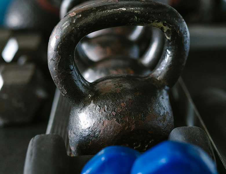 Varias pesas y mancuernas sobre un soporte